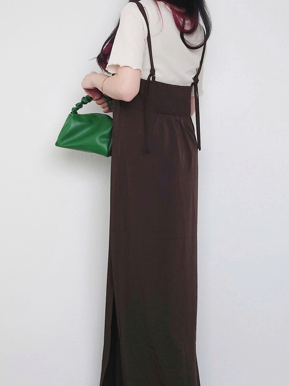 ブラウン系のワンピース、グリーン系のハンドバッグ、ベージュ系のトップスを着用したレディースの夏コーディネートの2枚目の写真