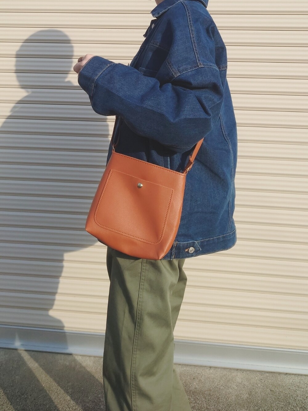 グリーン系のチノパンツ、ブラウン系のショルダーバッグ、グリーン系のパンプスを着用したレディースの冬コーディネートの2枚目の写真