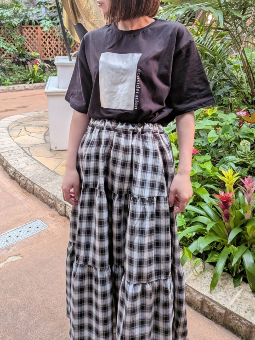 ブラック系のTシャツ/カットソー、ブラック系のスカート、ブラック系のサンダルを着用したレディースの春コーディネートの2枚目の写真