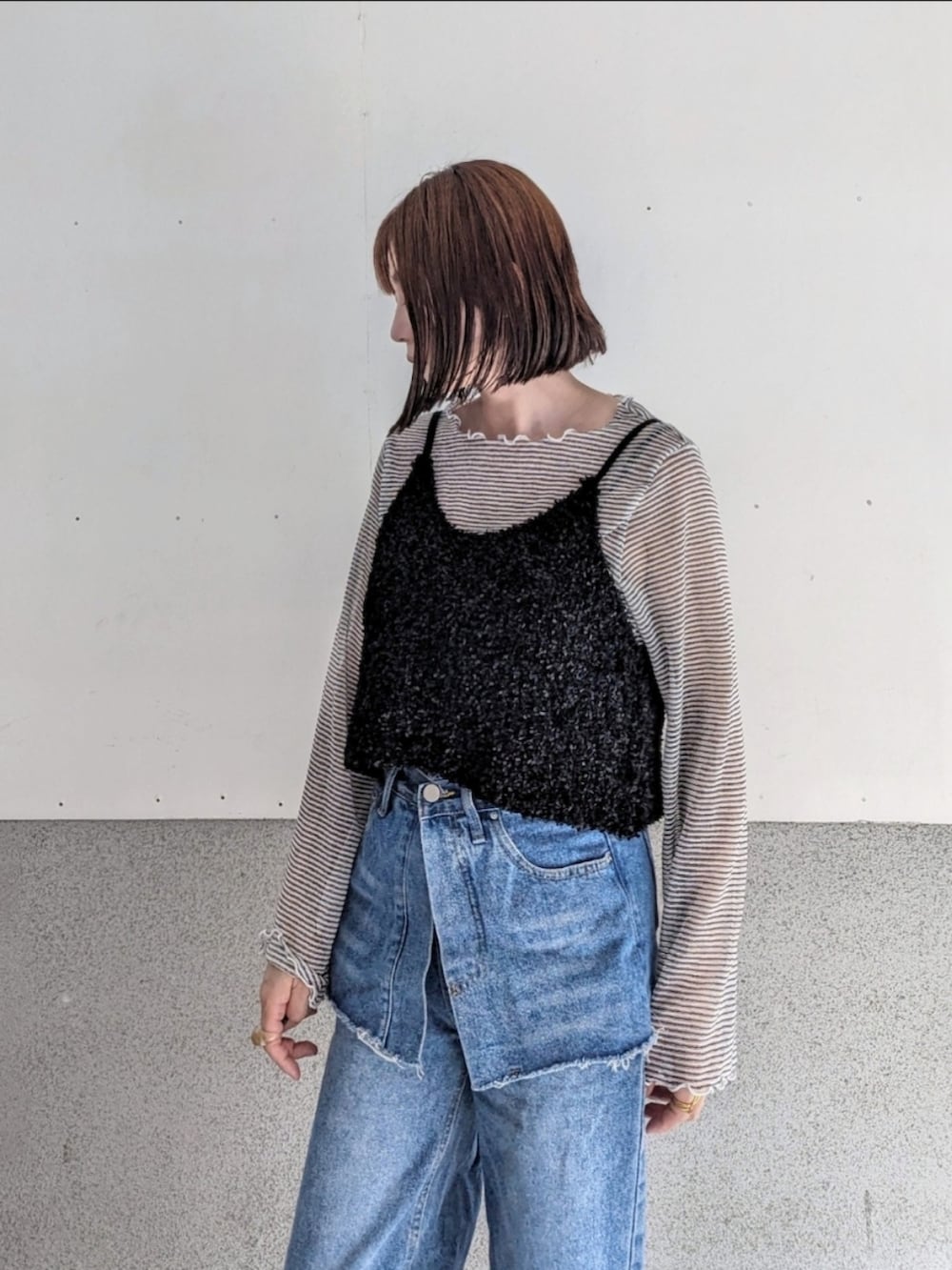 ブラック系のベスト、ホワイト系のTシャツ/カットソー、ブルー系のデニムパンツを着用したレディースの春コーディネートの3枚目の写真