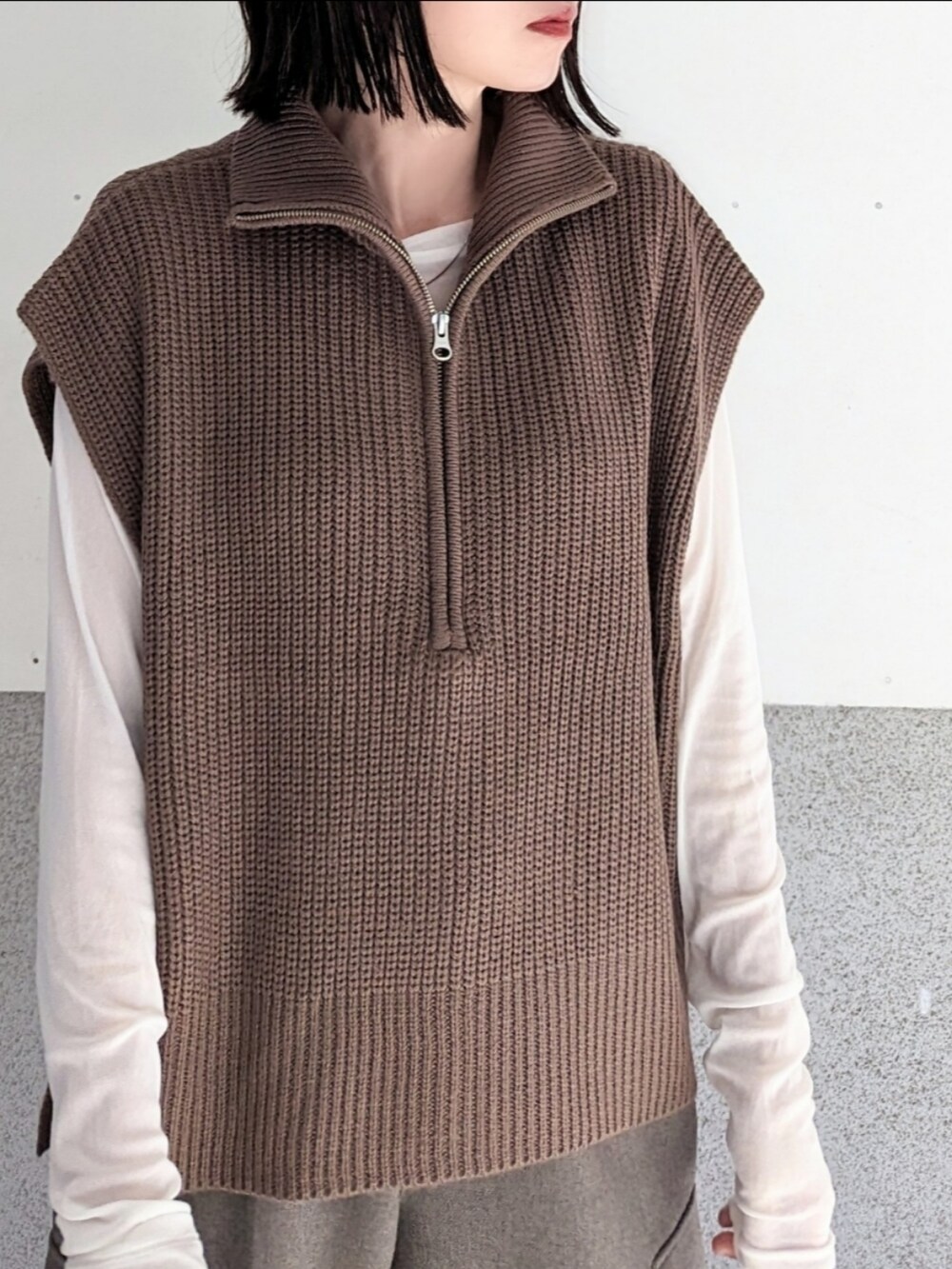 ブラウン系のベスト、ホワイト系のTシャツ/カットソー、ブラウン系のカーゴパンツを着用したレディースの秋コーディネートの3枚目の写真