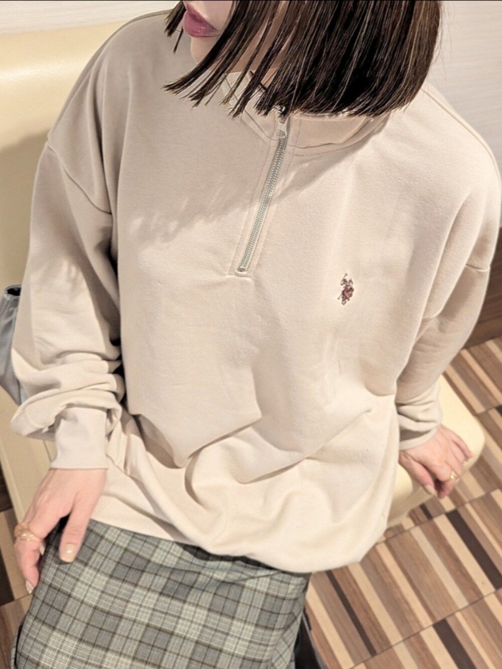 ベージュ系のスウェット、ブラック系のブーツ、グレー系のスカートを着用したレディースの秋コーディネートの2枚目の写真