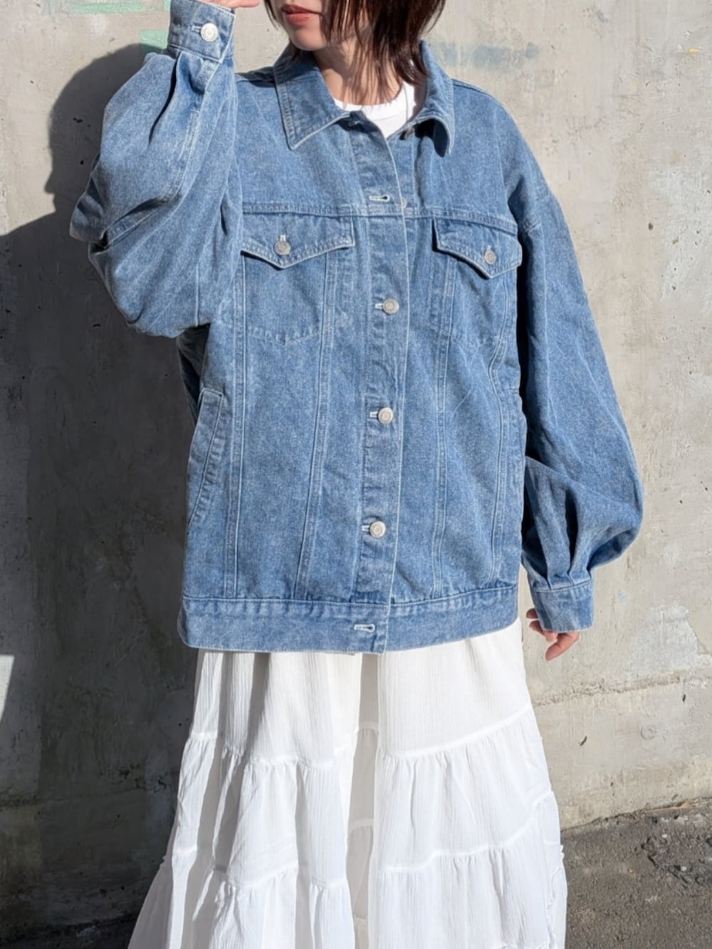 ブルー系のデニムジャケット、ホワイト系のスニーカーを着用したレディースの春コーディネートの2枚目の写真