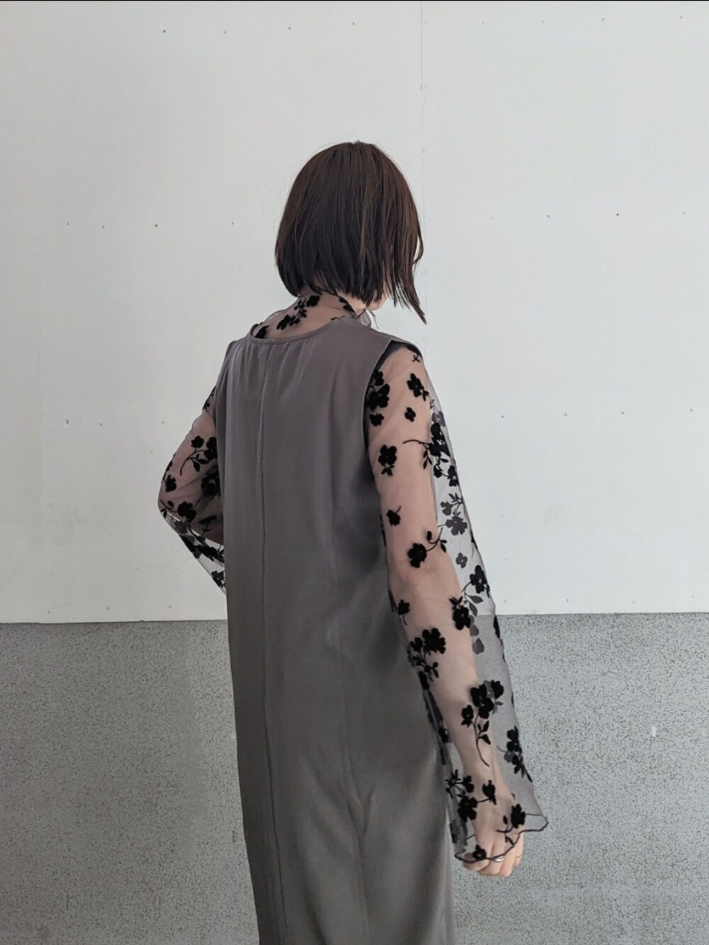 ブラウン系のその他トップス、グレー系のジャンパースカート、ホワイト系のハンドバッグを着用したレディースの冬コーディネートの2枚目の写真