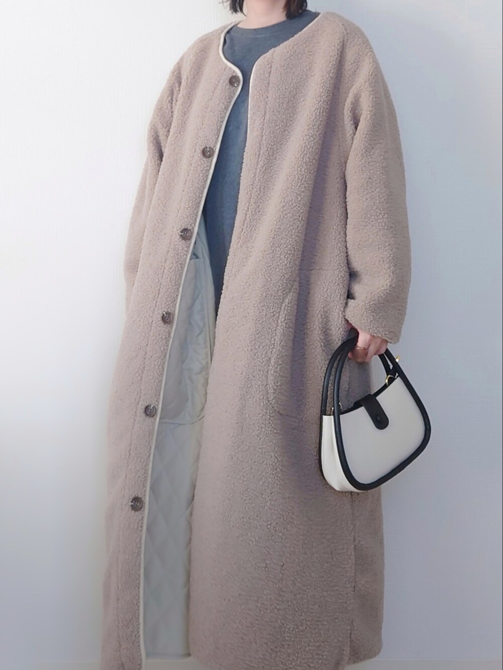 ホワイト系のその他アウター、ブラック系のスウェット、ブルー系のデニムパンツを着用したレディースの秋コーディネートの4枚目の写真