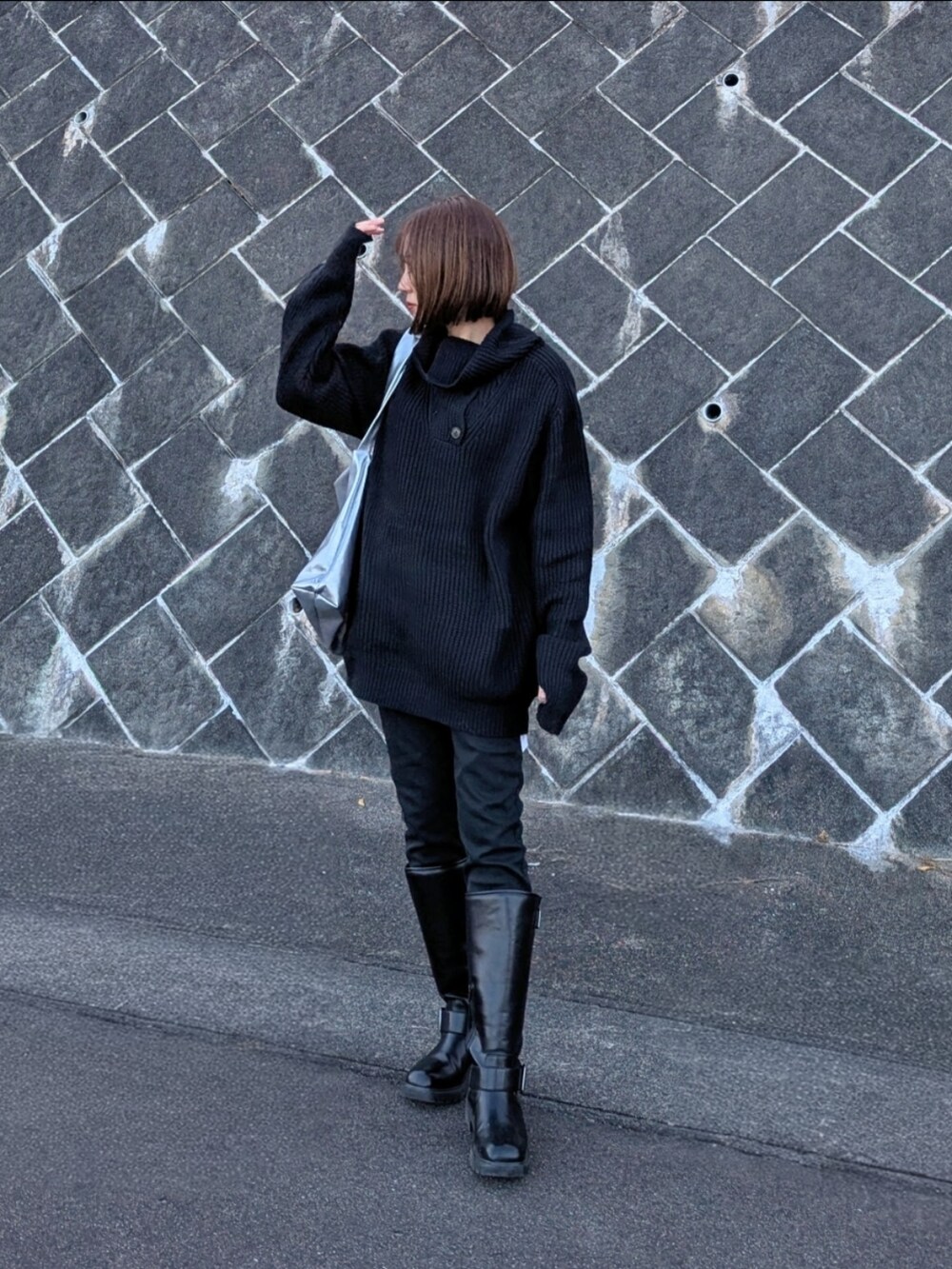 ブラック系のニット/セーター、ブラック系のその他パンツ、シルバー系のトートバッグを着用したレディースの冬コーディネートの2枚目の写真