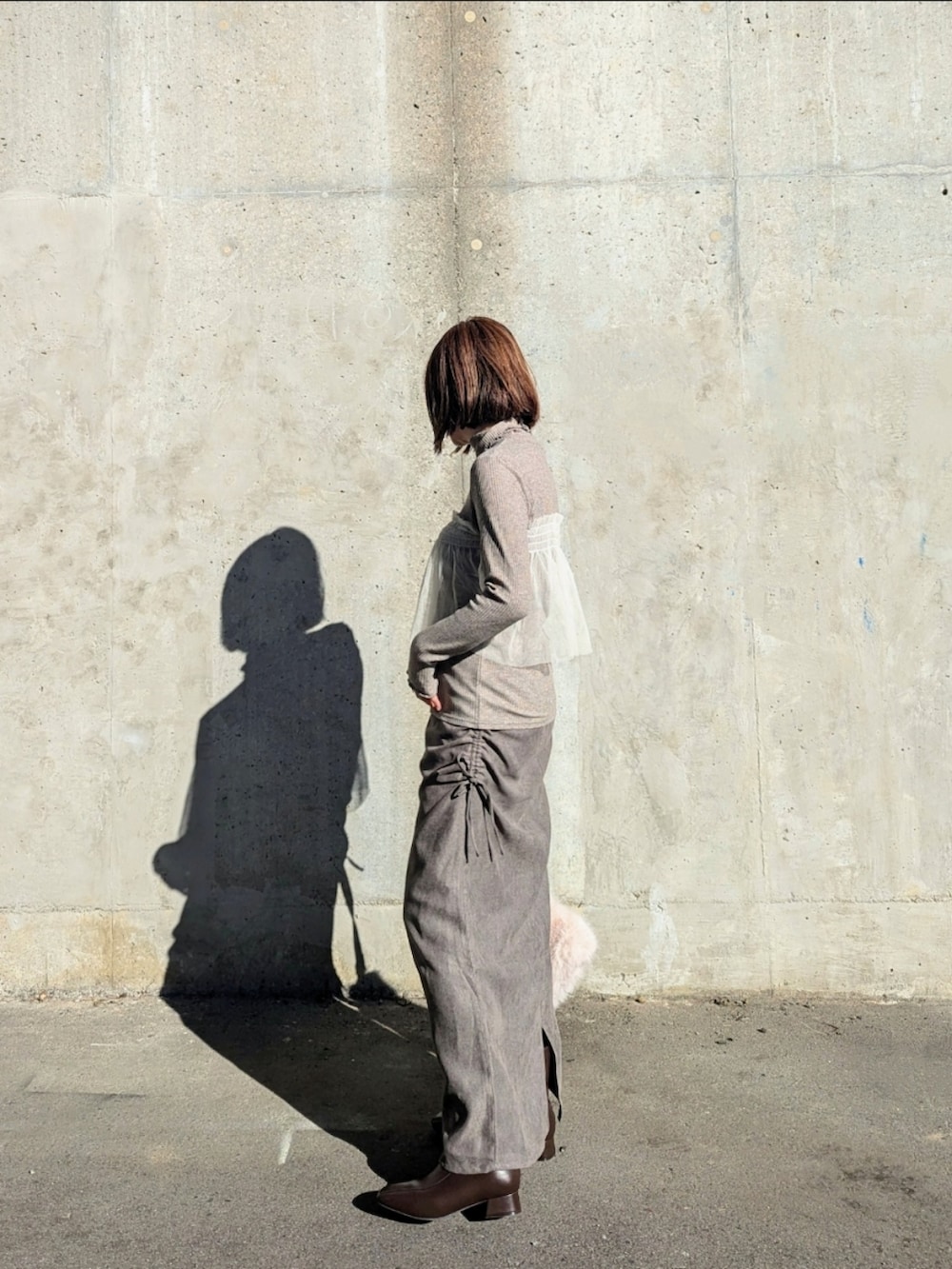 グレー系のTシャツ/カットソー、グレー系のスカートを着用したレディースの秋コーディネートの2枚目の写真