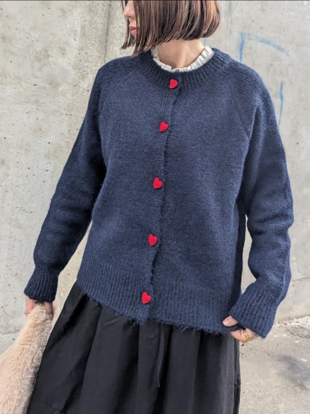 ブルー系のカーディガン/ボレロ、ブラック系のスカート、ホワイト系のシャツ/ブラウスを着用したレディースの秋コーディネートの4枚目の写真