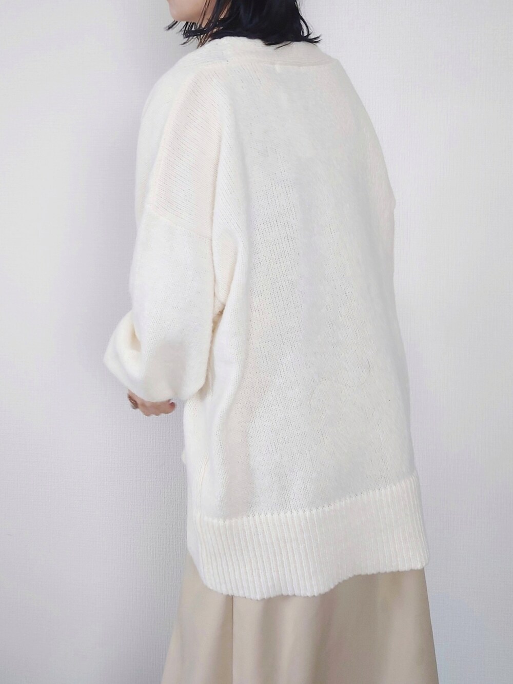 ホワイト系のニット/セーター、ベージュ系のワンピース、ホワイト系のTシャツ/カットソーを着用したレディースの秋コーディネートの2枚目の写真