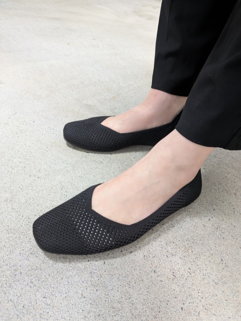 ブラック系のパンプス、ブラック系のトートバッグを着用したレディースの春コーディネートの3枚目の写真