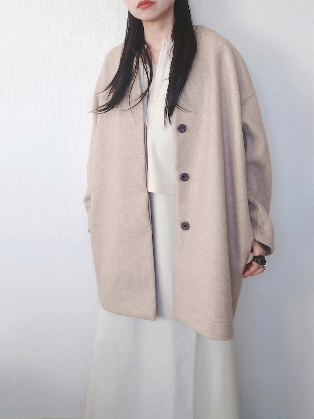 ホワイト系のその他アウター、ベージュ系のノーカラーコート、ホワイト系のブーツを着用したレディースの冬コーディネートの3枚目の写真