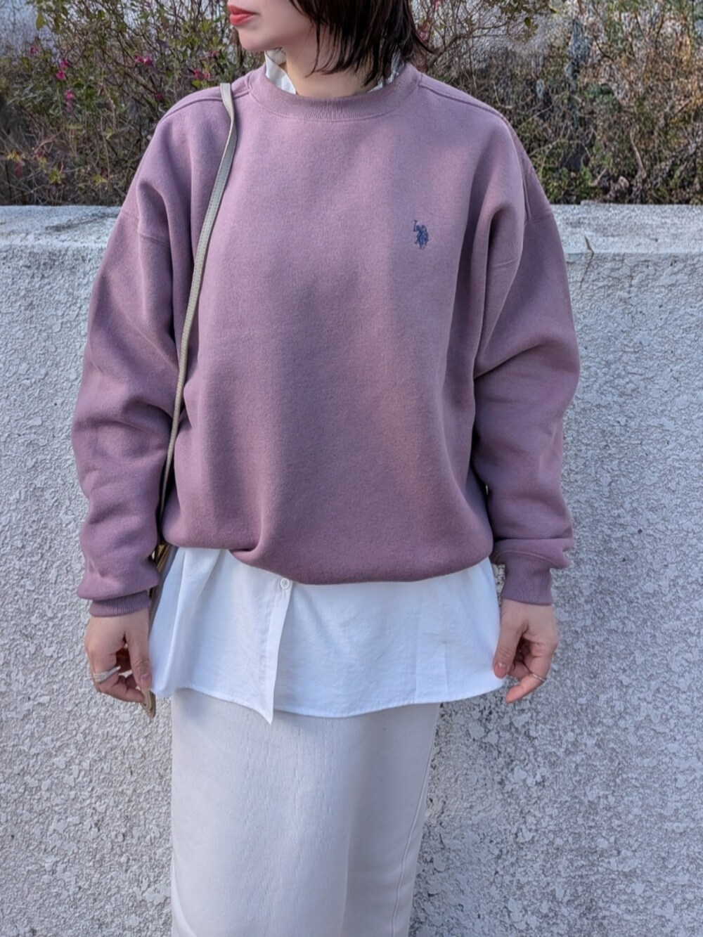 ピンク系のスウェット、ベージュ系のショルダーバッグ、ブラック系のブーツを着用したレディースの冬コーディネートの2枚目の写真