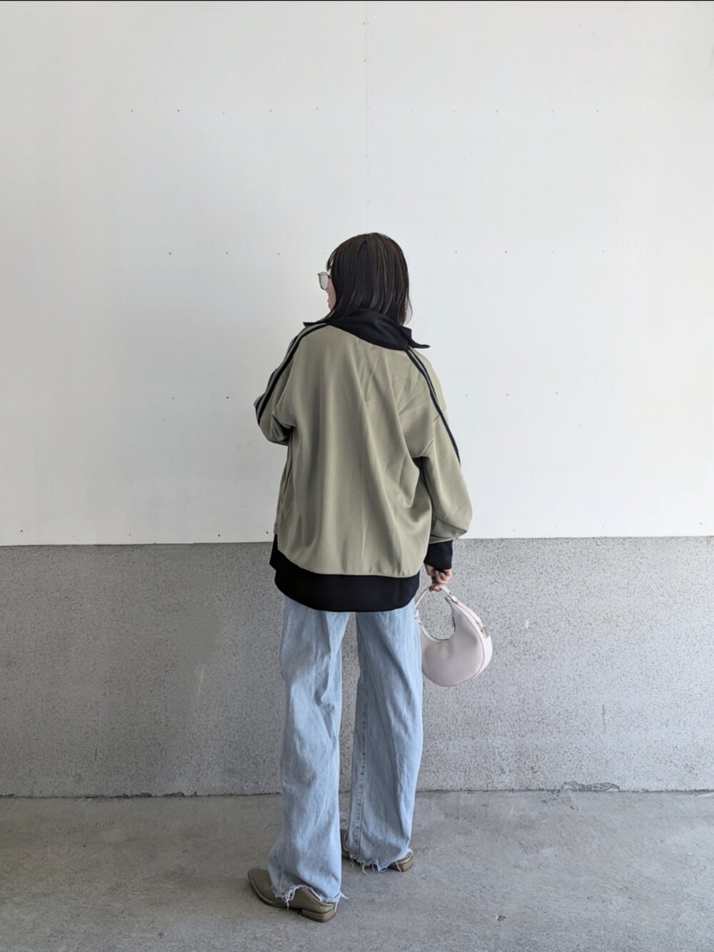 ベージュ系のジャージ、ホワイト系のTシャツ/カットソー、ホワイト系のハンドバッグを着用したレディースの秋コーディネートの2枚目の写真