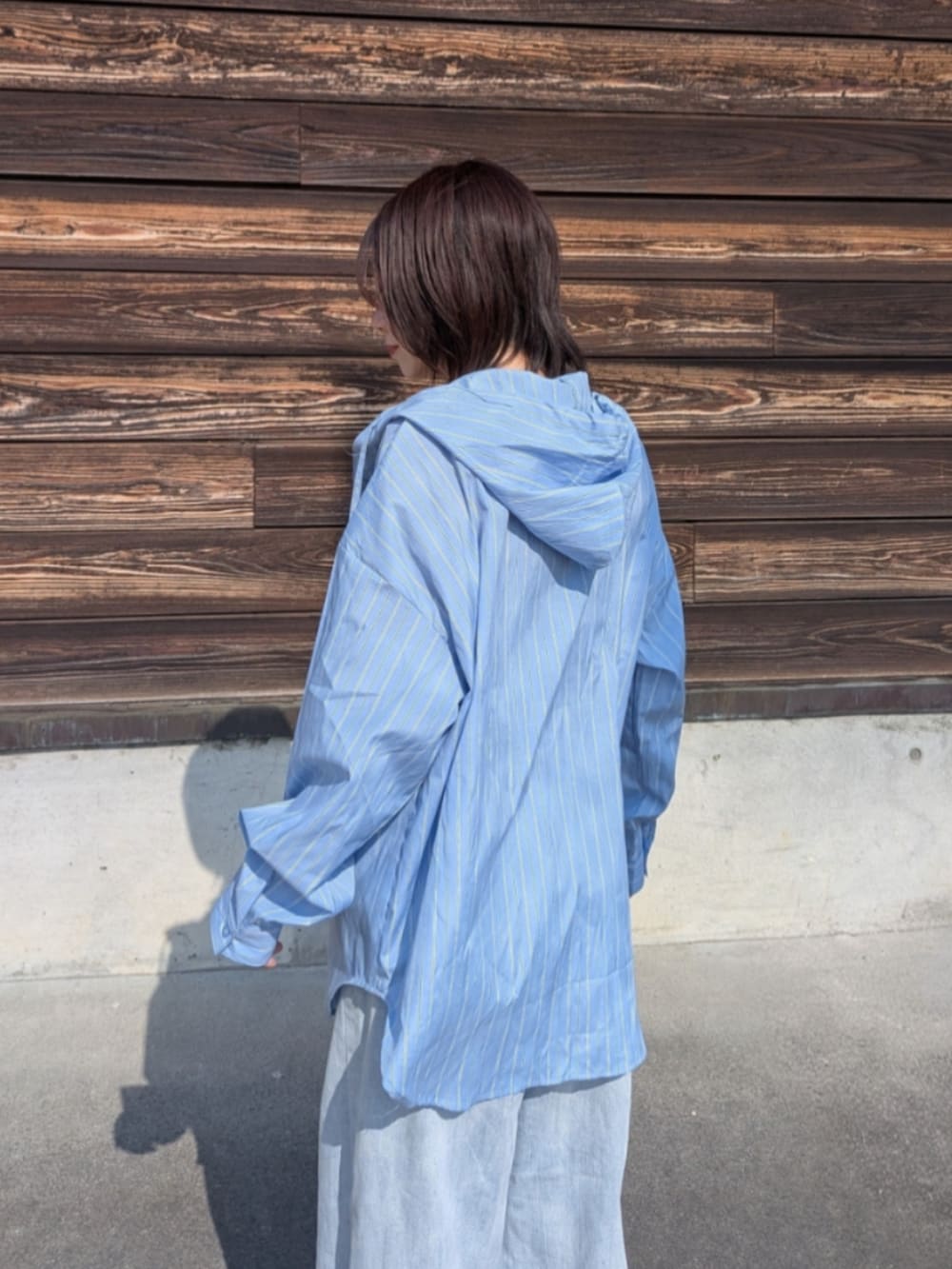 ブルー系のシャツ/ブラウス、ブルー系のデニムパンツ、ブラック系のパンプスを着用したレディースの春コーディネートの4枚目の写真