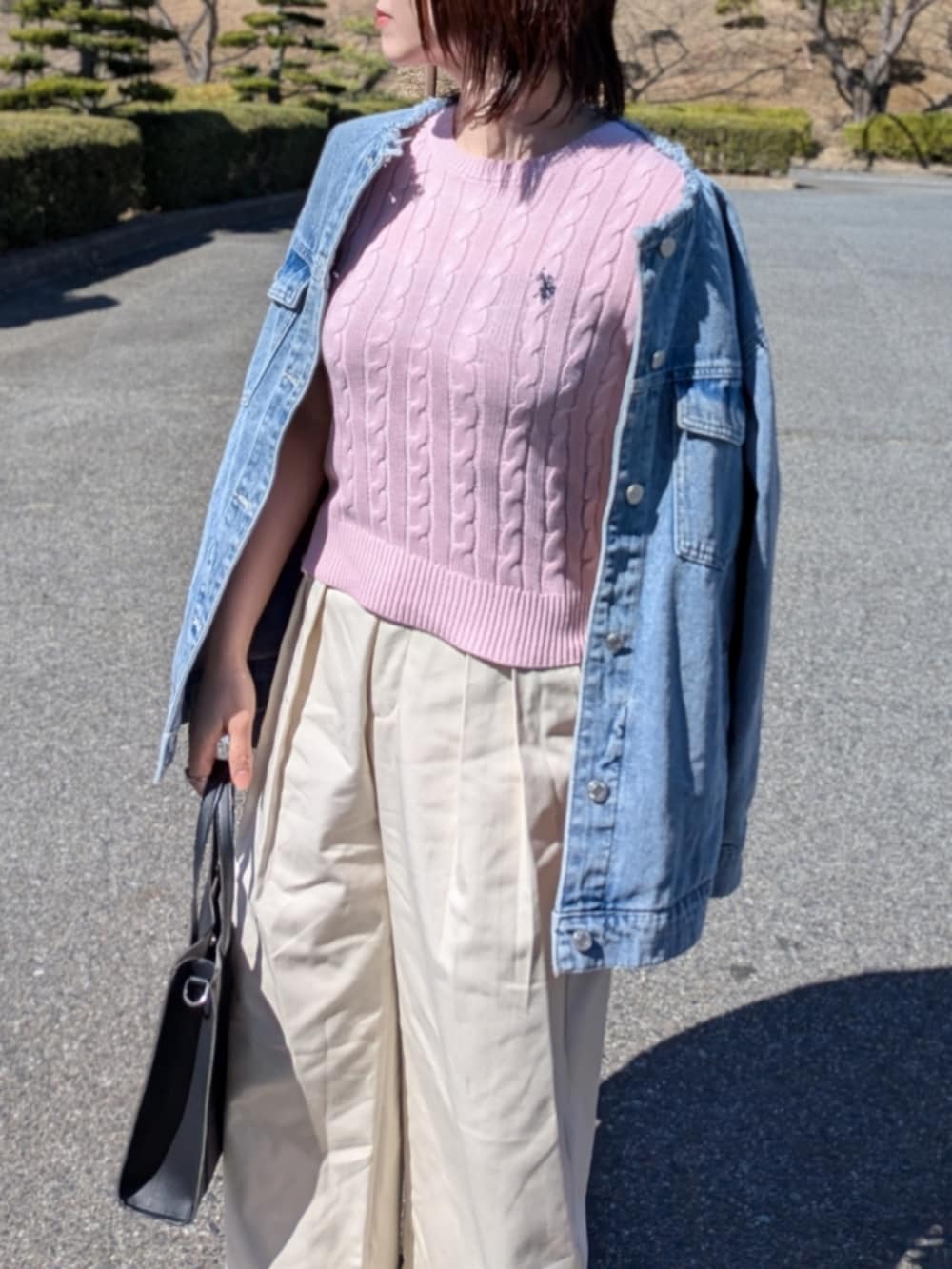 ピンク系のニット/セーター、ブルー系のデニムジャケット、ブラック系のショルダーバッグを着用したレディースの春コーディネートの5枚目の写真