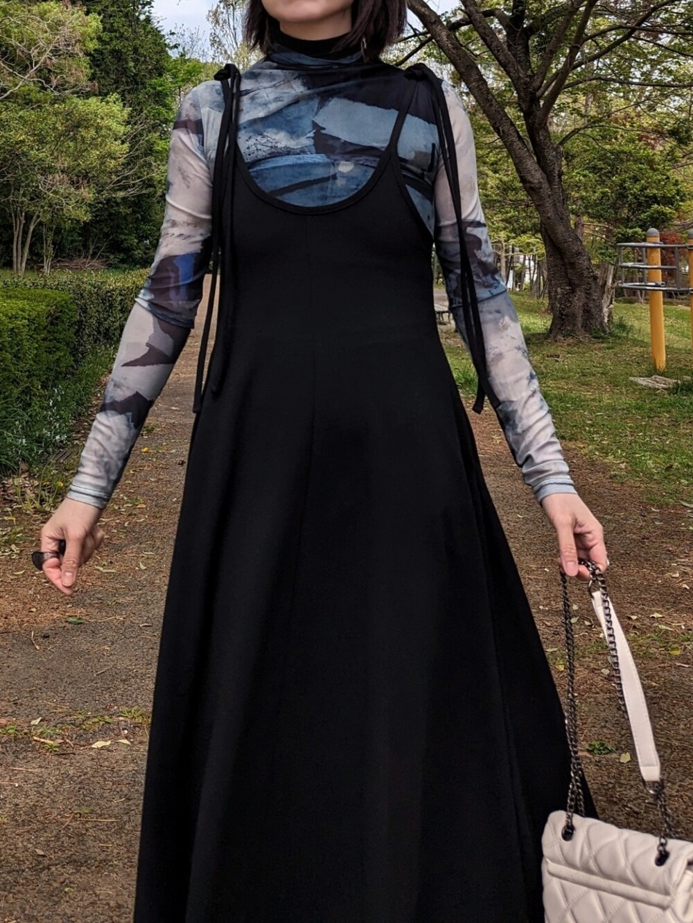 グリーン系のその他トップス、ブラック系のワンピース、ホワイト系のショルダーバッグを着用したレディースの春コーディネートの2枚目の写真