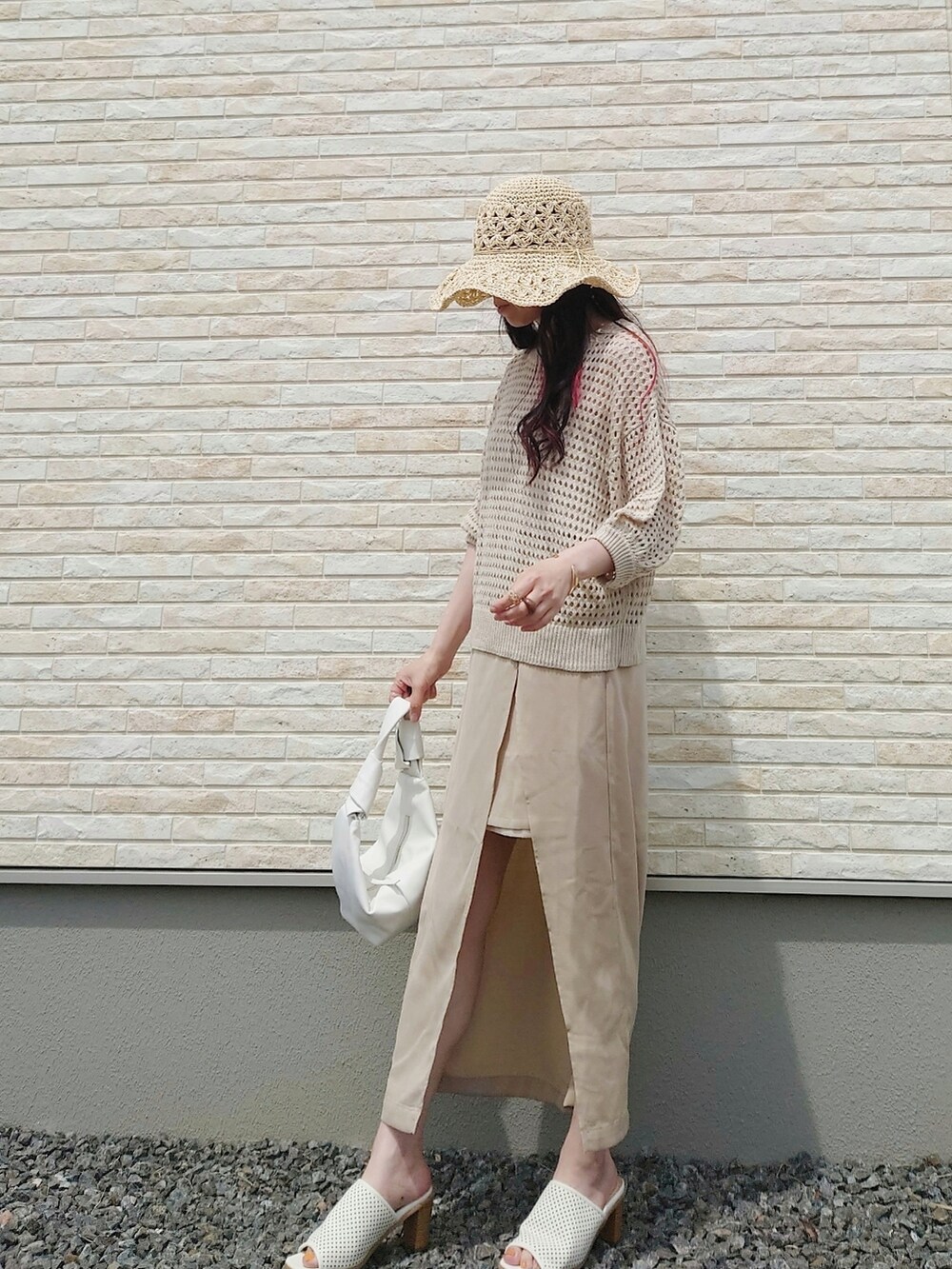 ベージュ系のベスト、ベージュ系のスカート、ベージュ系のボストンバッグを着用したレディースの春コーディネートの4枚目の写真