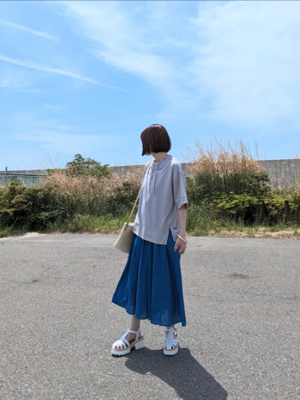 グレー系のTシャツ/カットソー、ブルー系のその他パンツ、ホワイト系のサンダルを着用したレディースの春コーディネートの3枚目の写真
