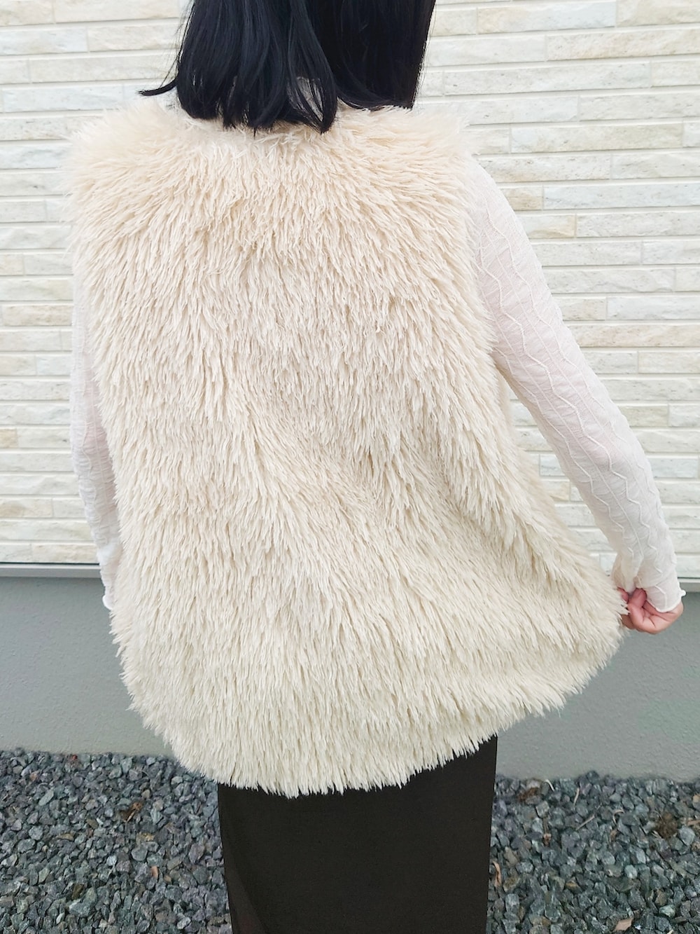 ホワイト系のベスト、ブラウン系のワンピース、レッド系のハンドバッグを着用したレディースの夏コーディネートの2枚目の写真