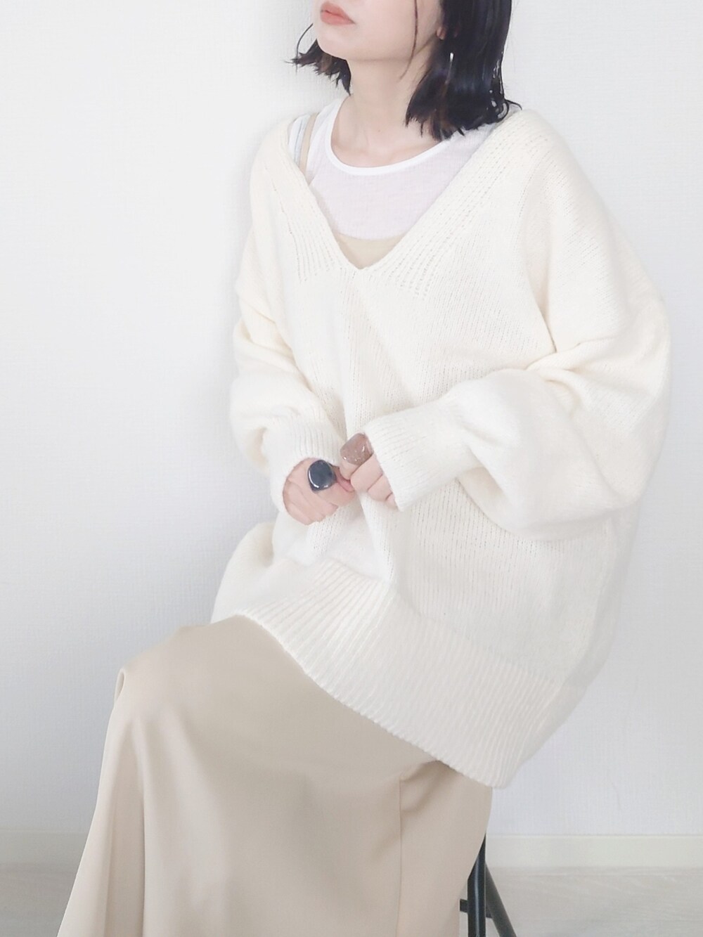 ホワイト系のニット/セーター、ベージュ系のワンピース、ホワイト系のTシャツ/カットソーを着用したレディースの秋コーディネートの3枚目の写真