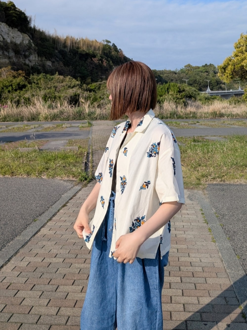 イエロー系のシャツ/ブラウス、ブルー系のデニムパンツ、ブラック系のタンクトップを着用したレディースの春コーディネートの2枚目の写真