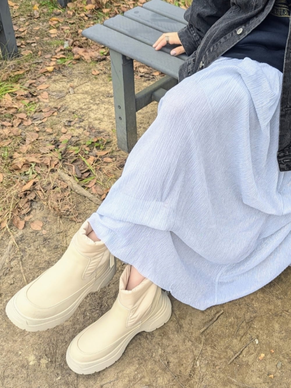 ブルー系のスウェット、ブラック系のデニムジャケット、ベージュ系のブーツを着用したレディースの秋コーディネートの2枚目の写真