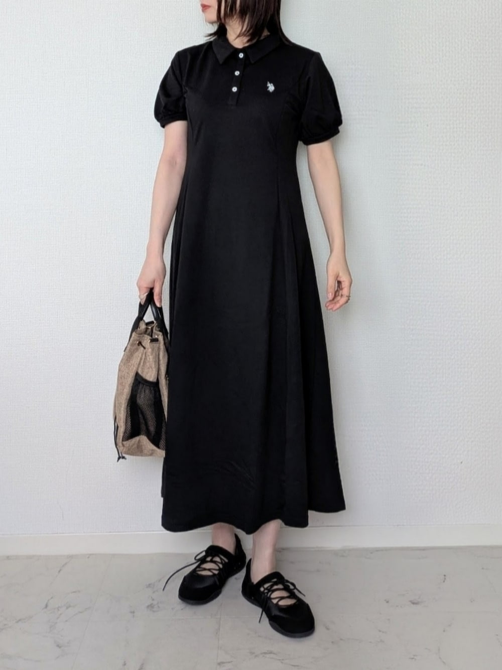 ブラック系のワンピース、ブルー系のデニムジャケット、ブラック系のパンプスを着用したレディースの春コーディネートの3枚目の写真