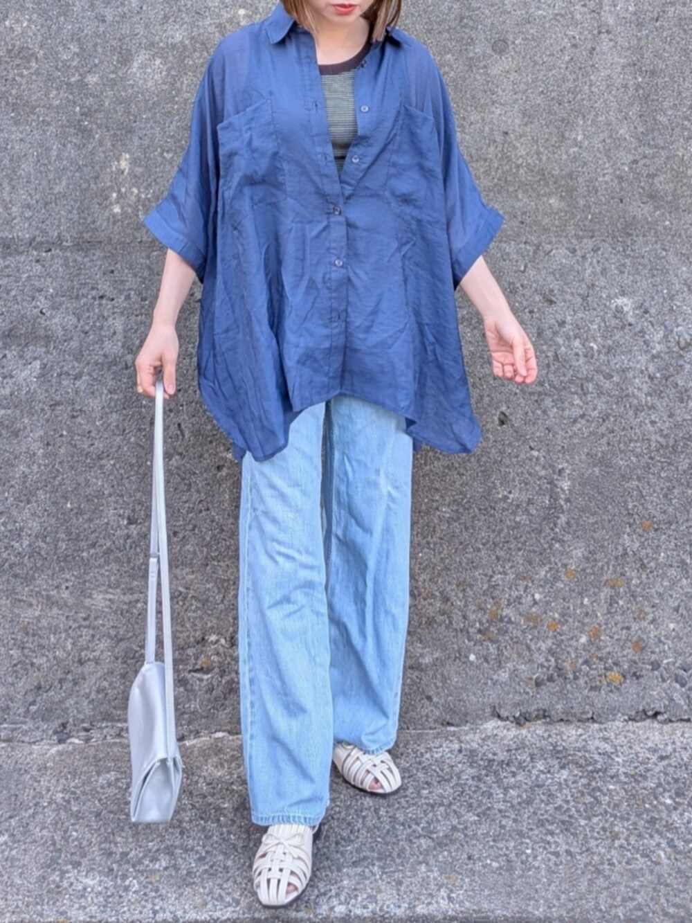 ブルー系のシャツ/ブラウス、ブラック系のタンクトップ、ホワイト系のサンダルを着用したレディースの春コーディネートの2枚目の写真