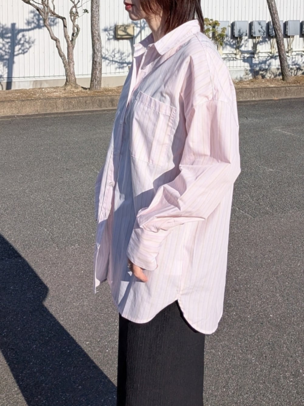 ピンク系のシャツ/ブラウス、ブルー系のデニムジャケット、ブラック系のパンプスを着用したレディースの春コーディネートの5枚目の写真