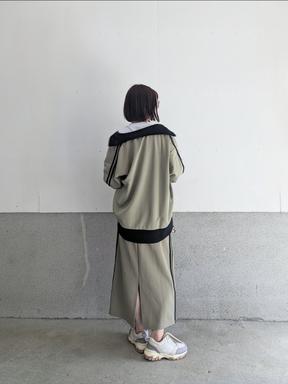 ベージュ系のジャージ、ブルー系のスカート、ホワイト系のTシャツ/カットソーを着用したレディースの夏コーディネートの2枚目の写真