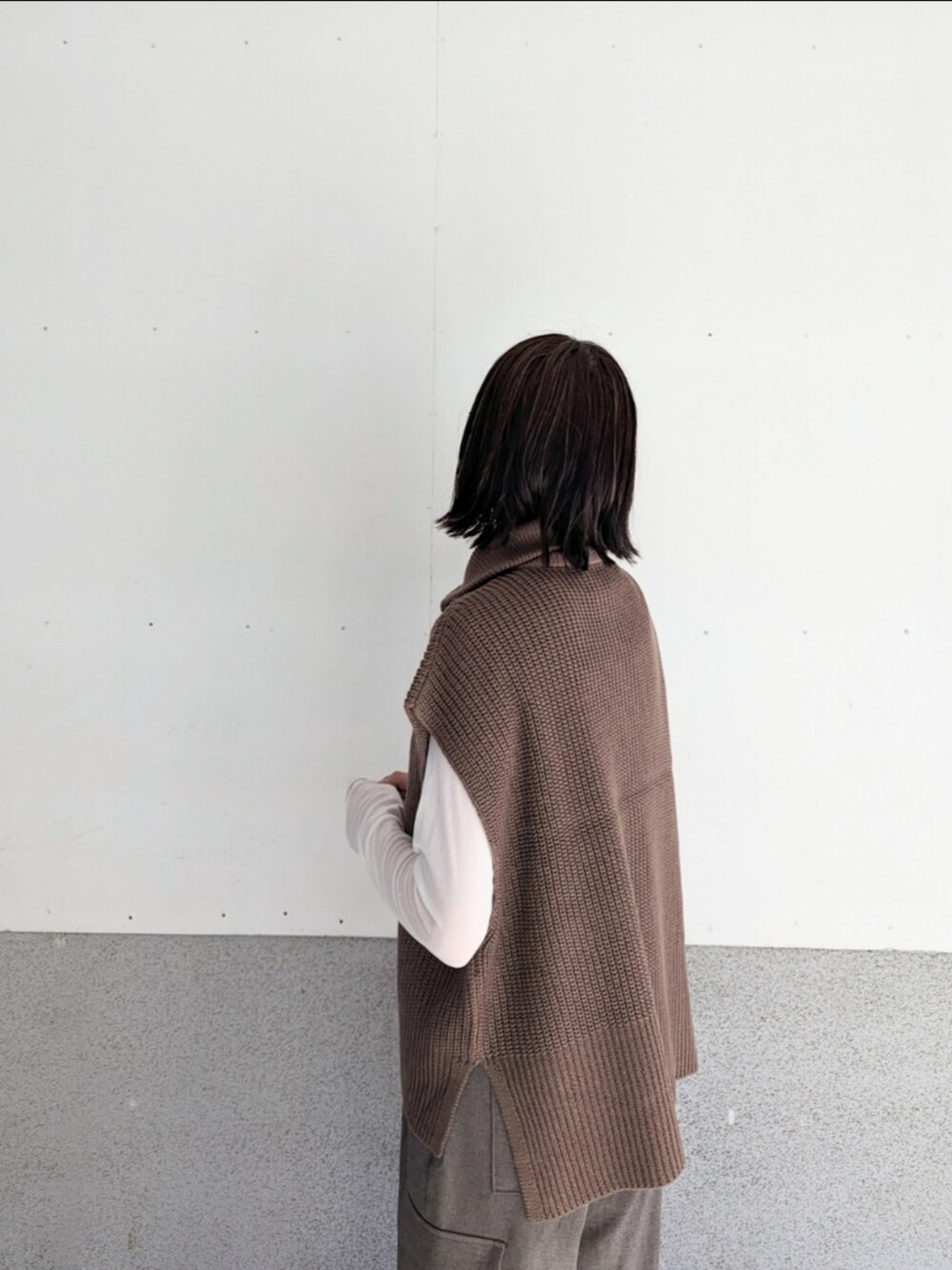ブラウン系のベスト、ホワイト系のTシャツ/カットソー、ブラウン系のカーゴパンツを着用したレディースの秋コーディネートの4枚目の写真