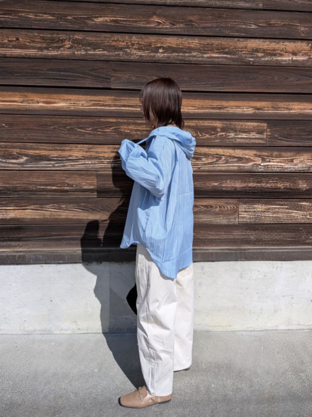 ブルー系のシャツ/ブラウス、ブラック系のショルダーバッグ、ベージュ系のローファーを着用したレディースの春コーディネートの2枚目の写真