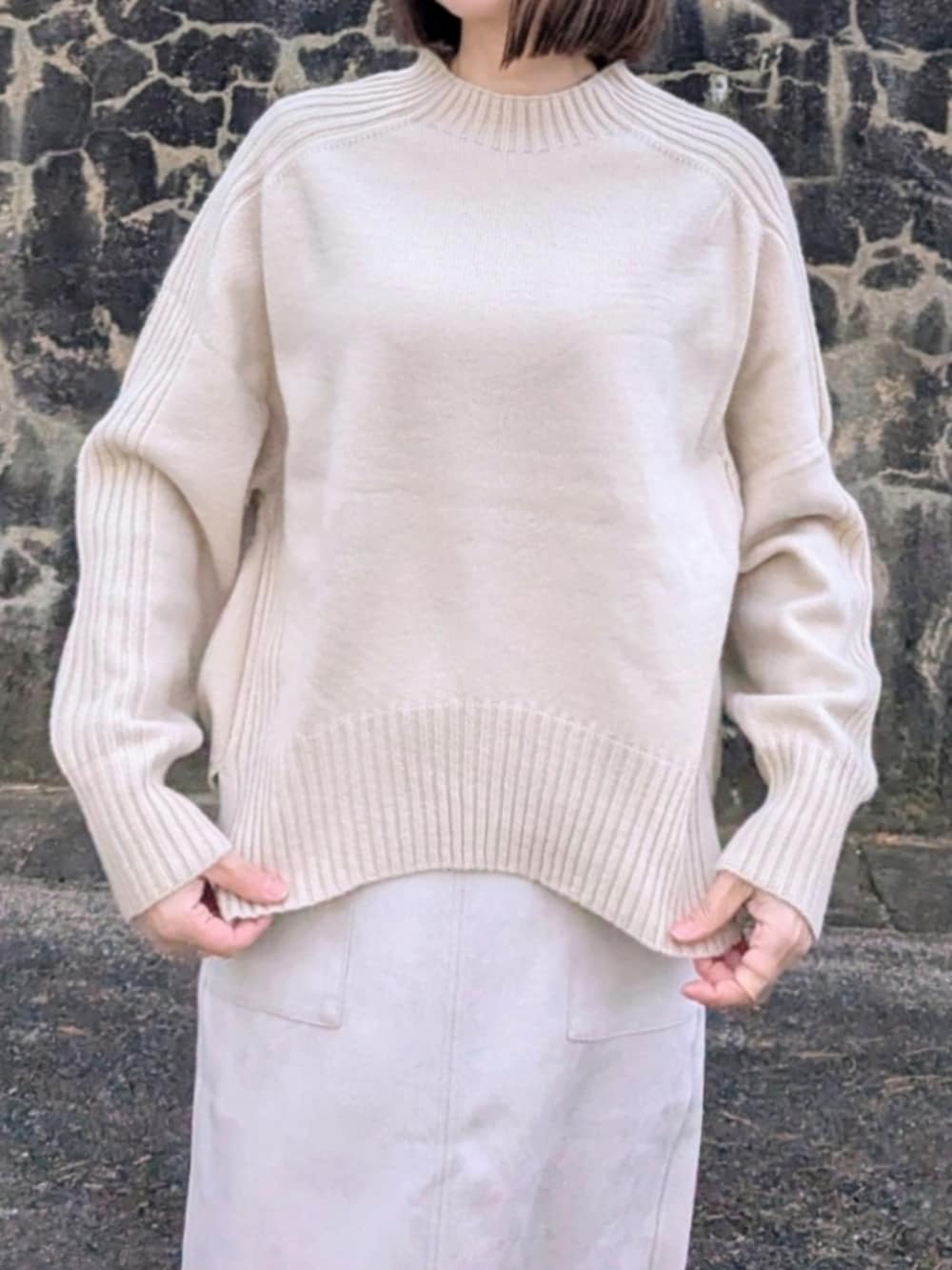 ベージュ系のニット/セーター、ベージュ系のスカート、レッド系のブルゾンを着用したレディースの冬コーディネートの4枚目の写真