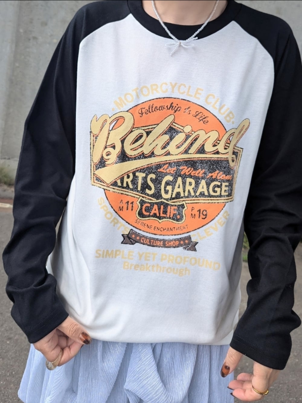 ブラック系のTシャツ/カットソー、シルバー系のワンピース、ブラック系のショルダーバッグを着用したレディースの秋コーディネートの3枚目の写真