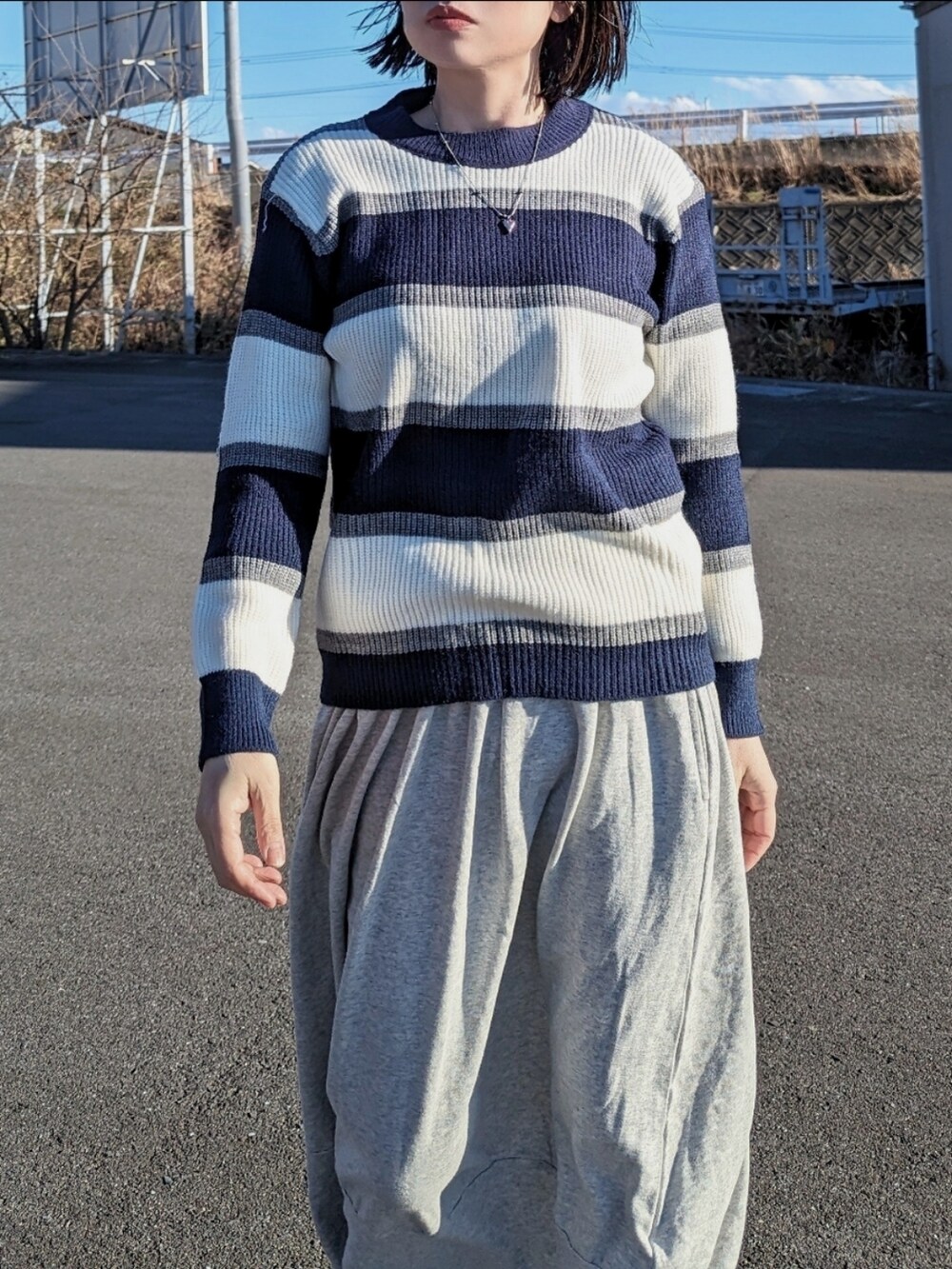 ブルー系のニット/セーター、グレー系のベスト、ブラウン系のトートバッグを着用したレディースの冬コーディネートの3枚目の写真