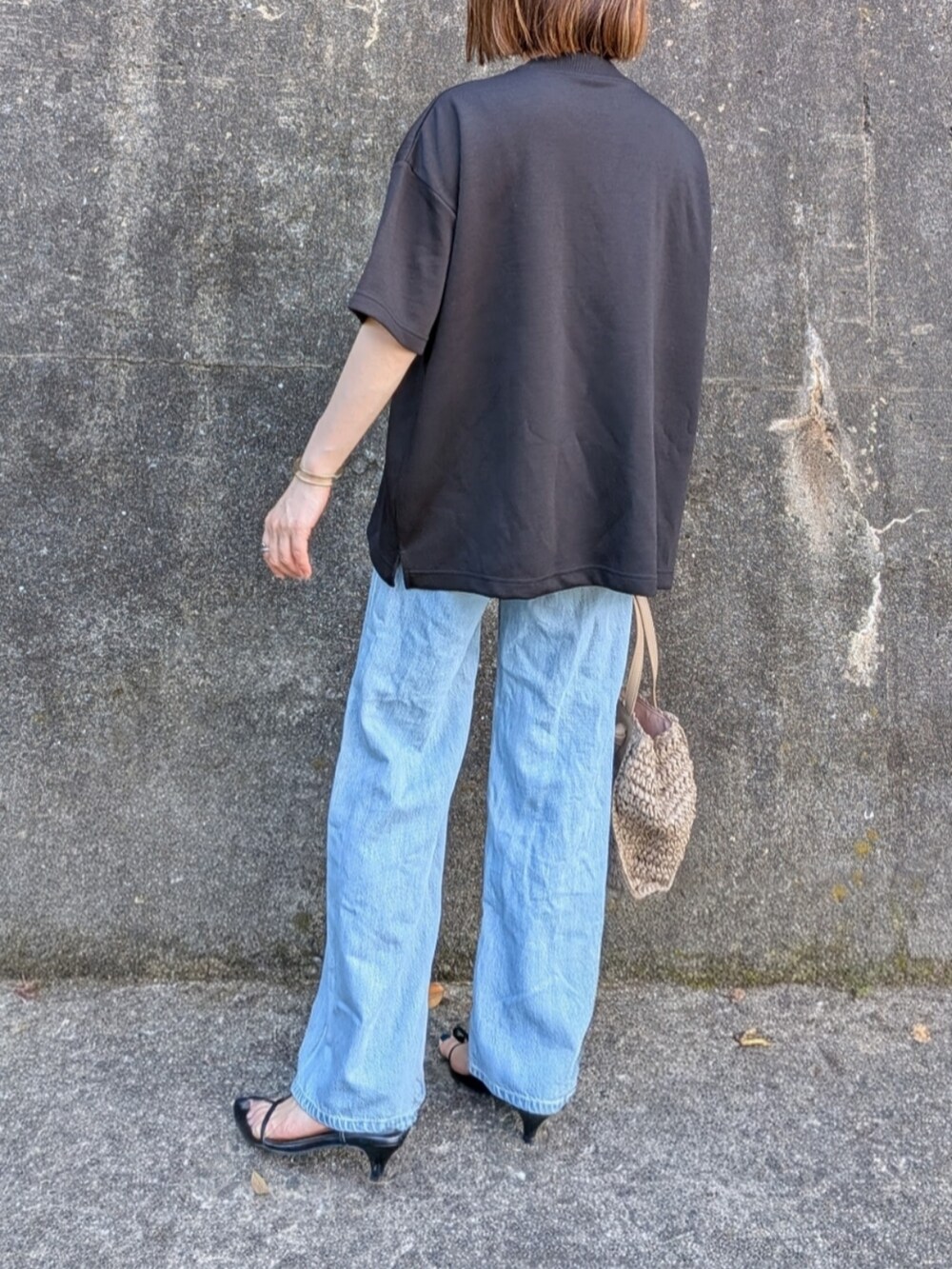 ブラック系のTシャツ/カットソー、ピンク系のかごバッグ、ブラック系のサンダルを着用したレディースの夏コーディネートの3枚目の写真