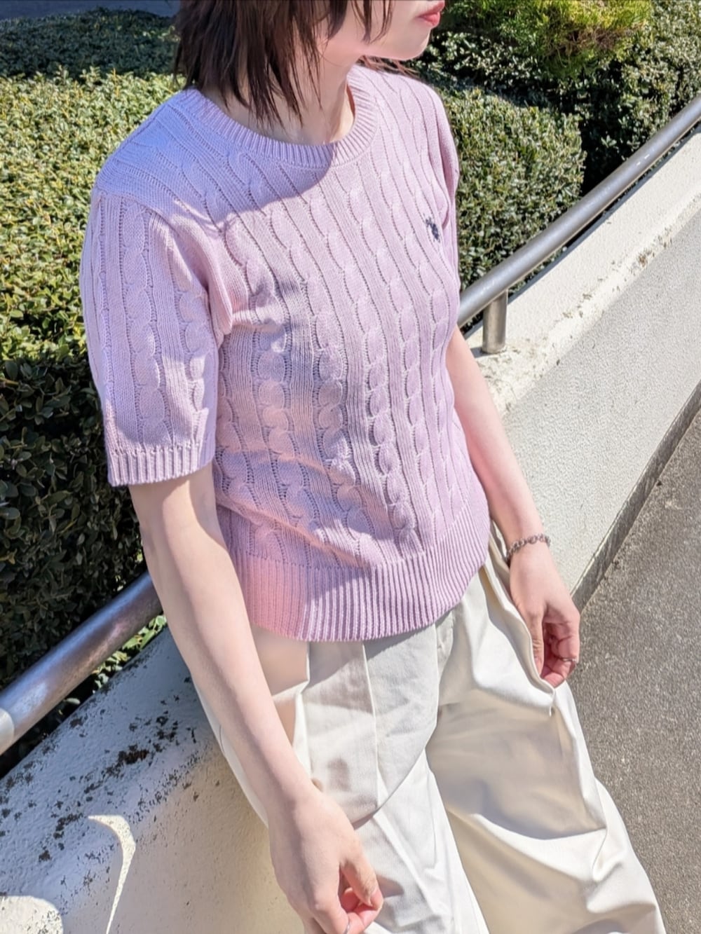 ピンク系のニット/セーター、ブルー系のデニムジャケット、ブラック系のショルダーバッグを着用したレディースの春コーディネートの4枚目の写真