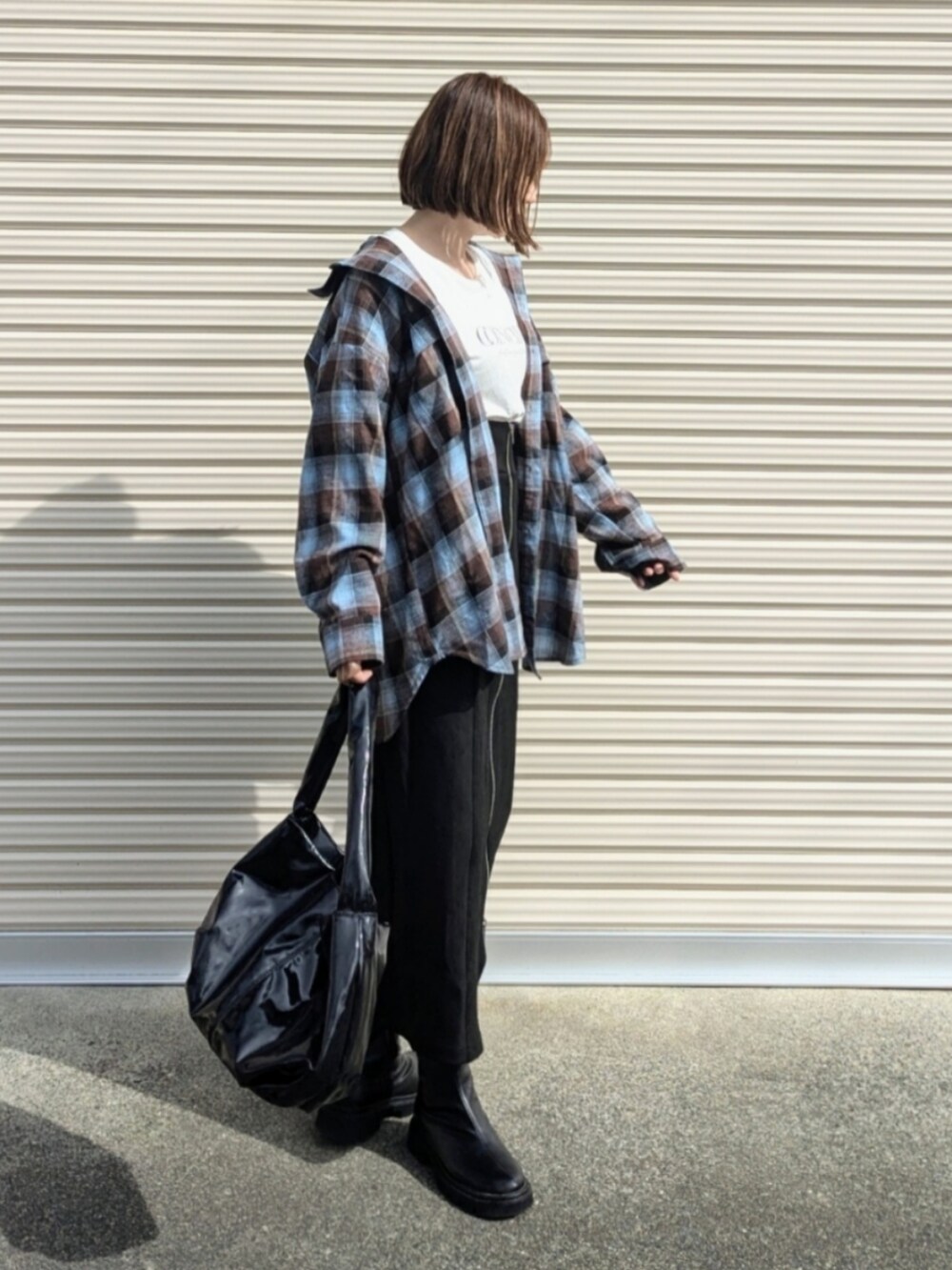 ブラウン系のシャツ/ブラウス、ブラック系のスカート、ブラック系のブーツを着用したレディースの秋コーディネートの2枚目の写真