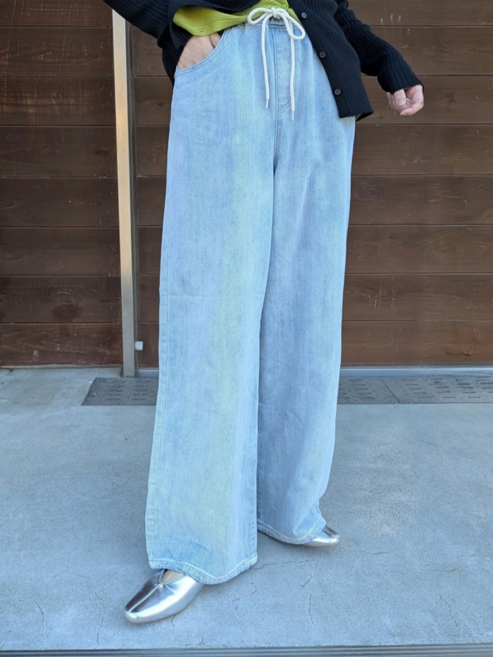 ブルー系のデニムパンツ、ブラック系のショルダーバッグ、ピンク系のカーディガン/ボレロを着用したレディースの春コーディネートの3枚目の写真