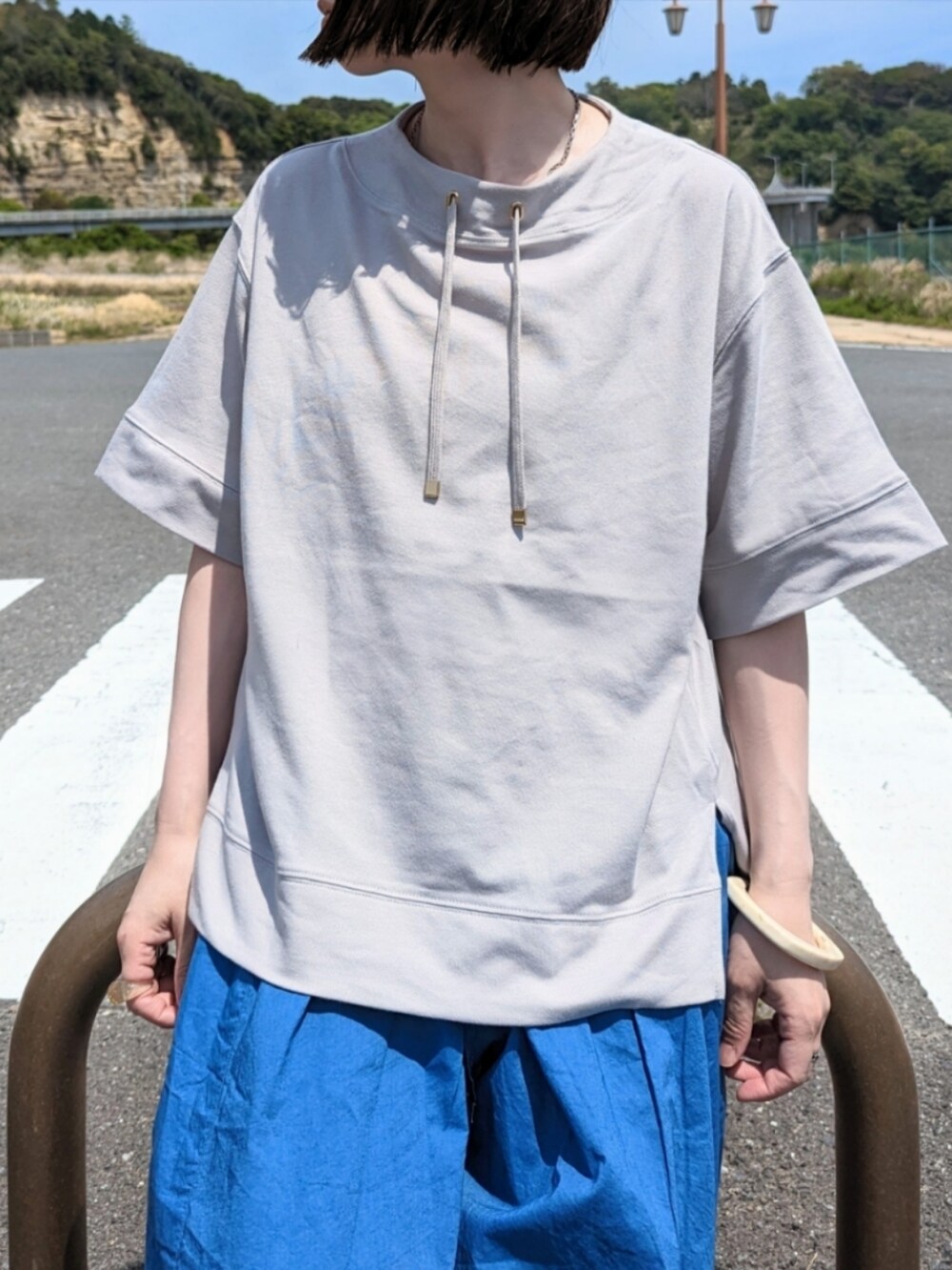 グレー系のTシャツ/カットソー、ブルー系のその他パンツ、ホワイト系のサンダルを着用したレディースの春コーディネートの2枚目の写真
