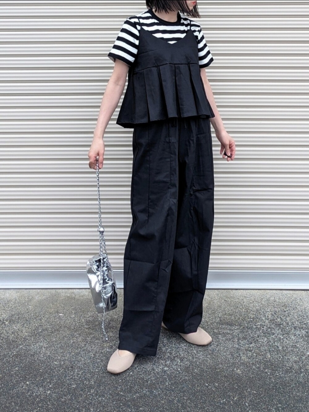ブラック系のセットアップ、ブラック系のTシャツ/カットソー、シルバー系のショルダーバッグを着用したレディースの春コーディネートの4枚目の写真