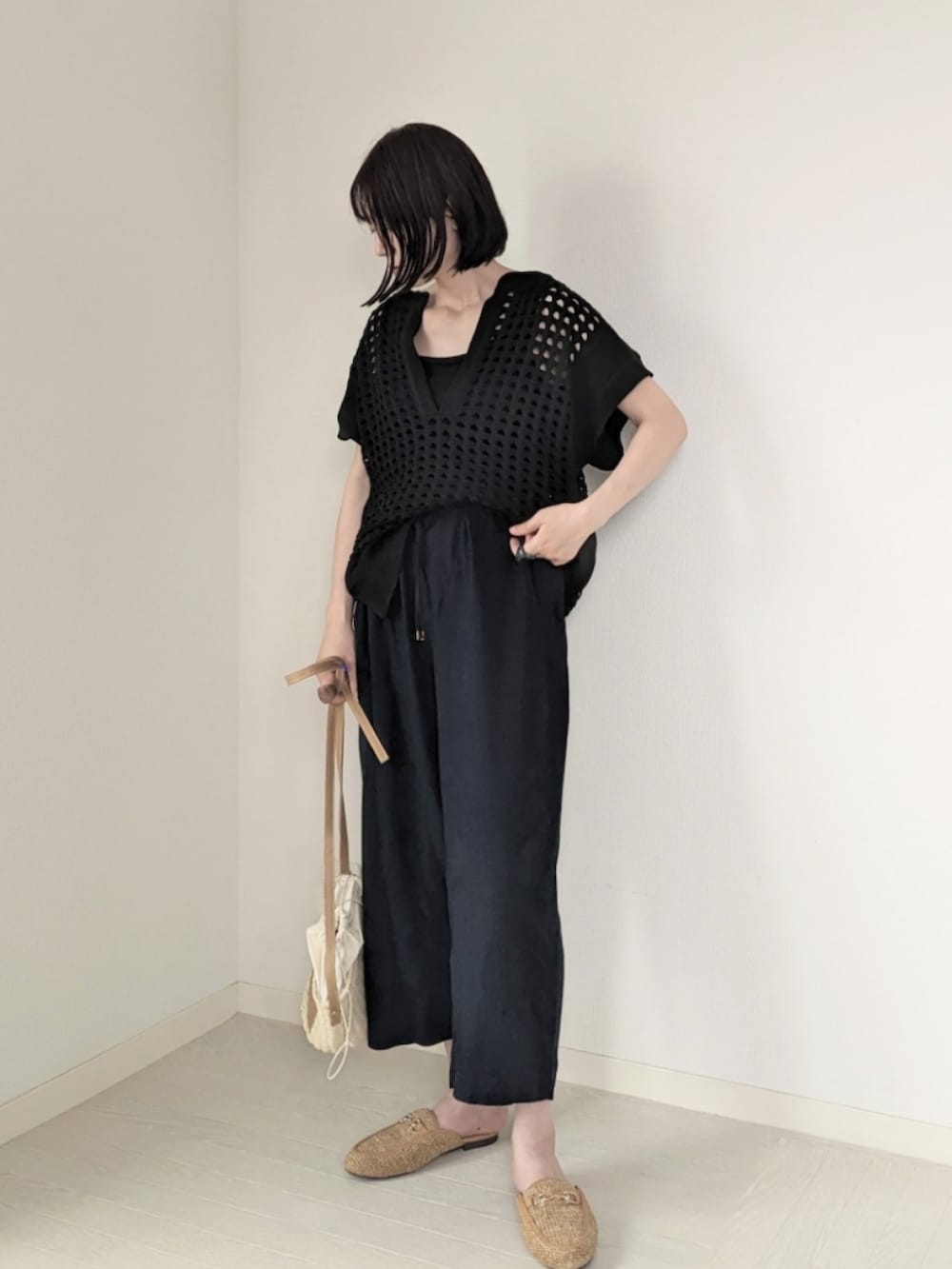 ブラック系のベスト、ブルー系のその他パンツ、ブラック系のタンクトップを着用したレディースの夏コーディネートの2枚目の写真