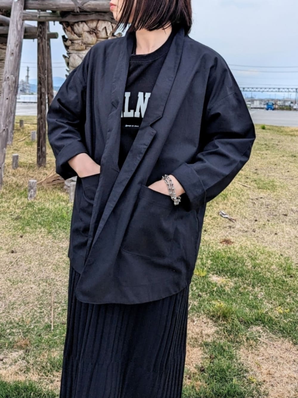 ブラック系のテーラードジャケット、ブラック系のスカート、ブラック系のTシャツ/カットソーを着用したレディースの春コーディネートの3枚目の写真