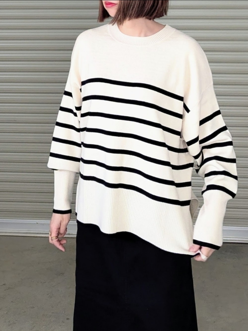 ホワイト系のニット/セーター、ブラック系のスカート、ベージュ系のノーカラーコートを着用したレディースの秋コーディネートの3枚目の写真