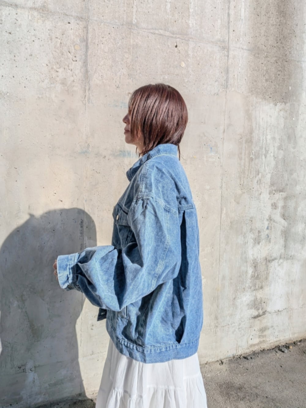 ブルー系のデニムジャケット、ホワイト系のスニーカーを着用したレディースの春コーディネートの3枚目の写真