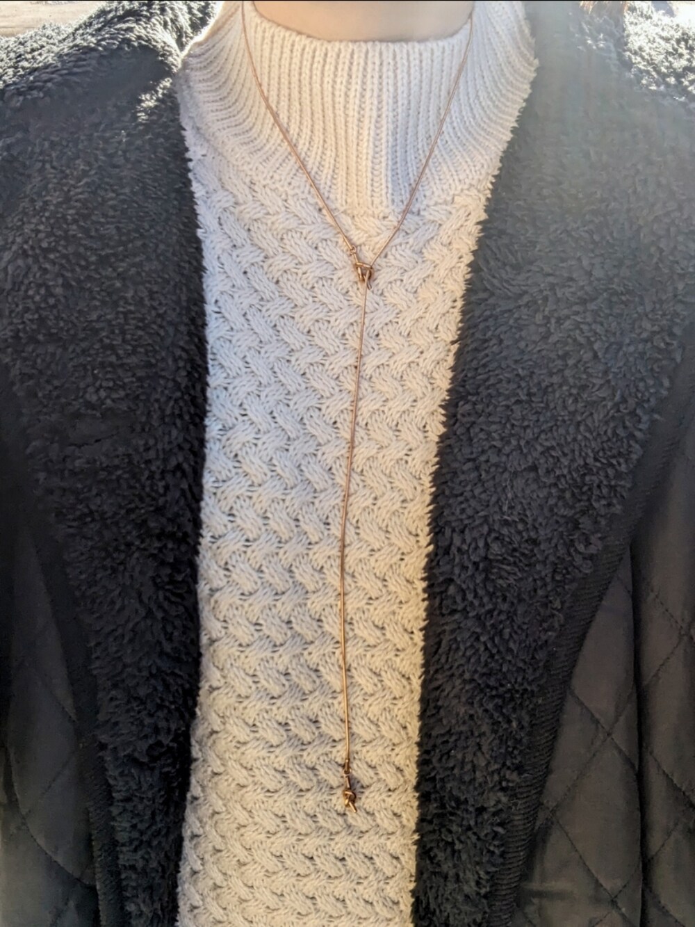 ブラック系のナイロンジャケット、ホワイト系のワンピース、シルバー系のショルダーバッグを着用したレディースの冬コーディネートの3枚目の写真