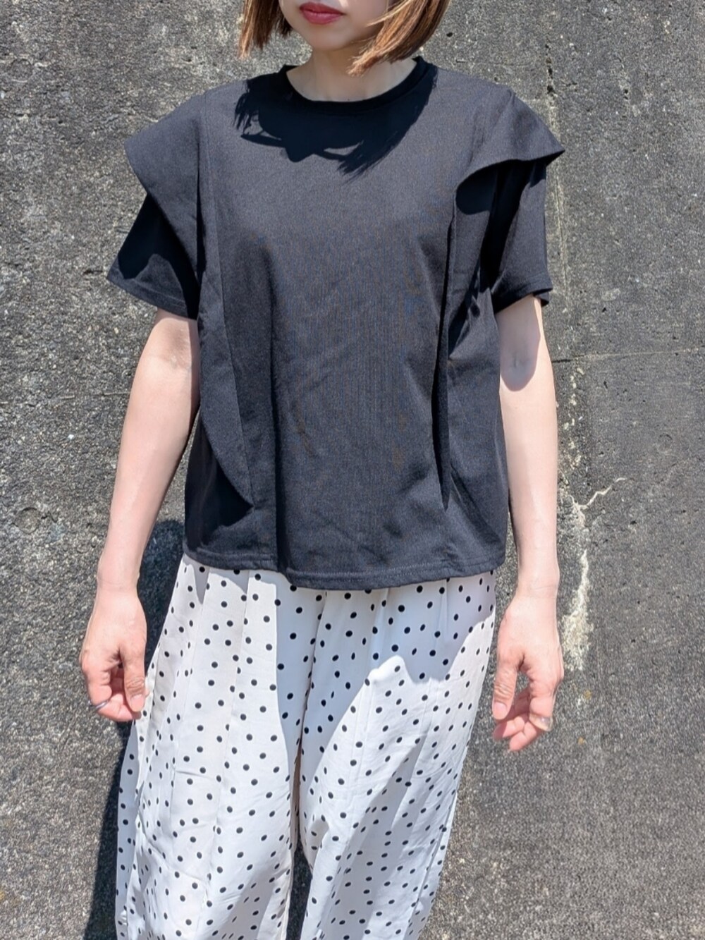 ブラック系のTシャツ/カットソー、ブラック系のサンダル、ブラウン系のショルダーバッグを着用したレディースの夏コーディネートの2枚目の写真