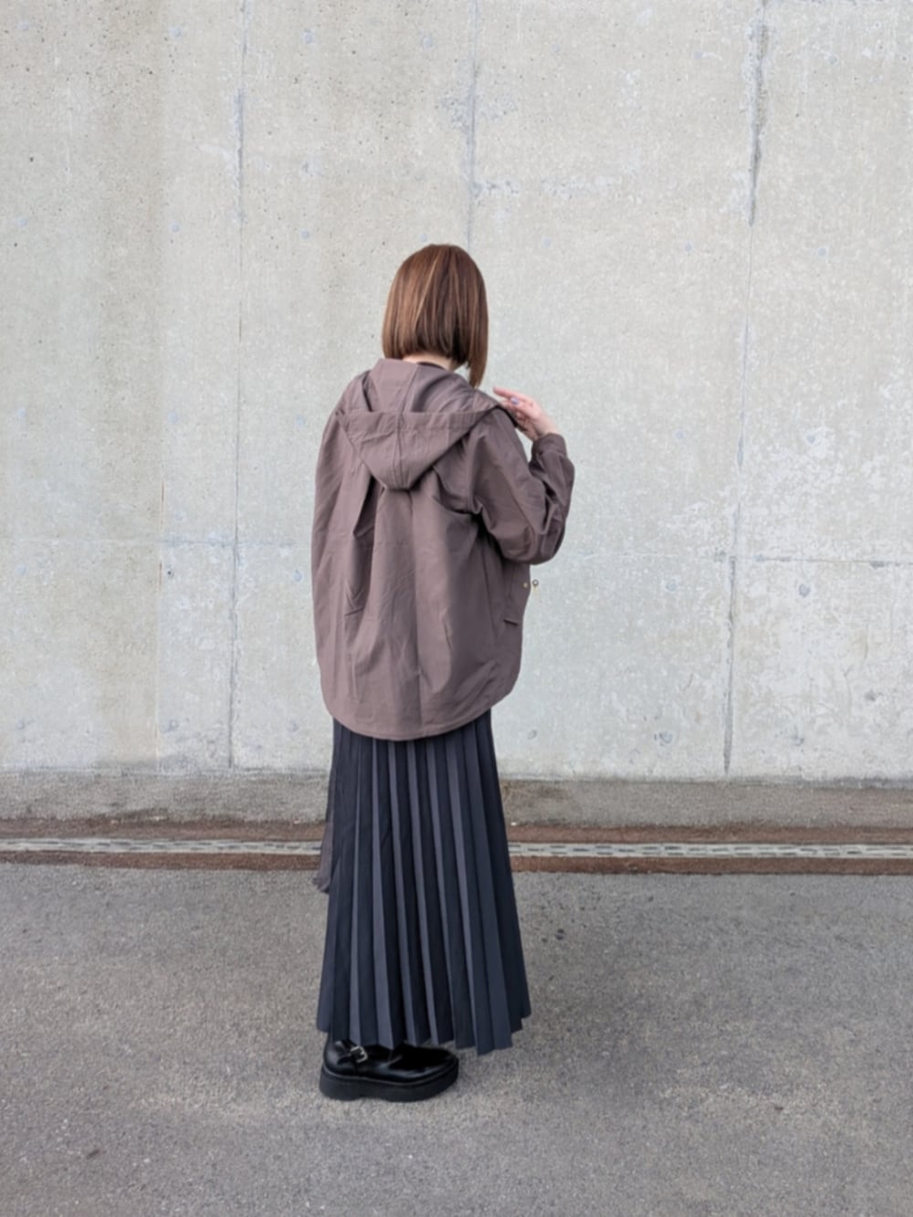 ブラウン系のブルゾン、ブラック系のスウェット、グレー系のスカートを着用したレディースの秋コーディネートの4枚目の写真