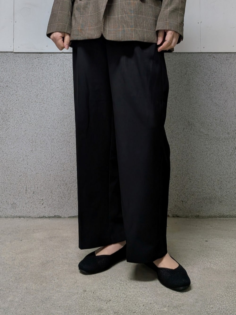 ブラック系のパンプス、ブラック系のトートバッグを着用したレディースの春コーディネートの2枚目の写真