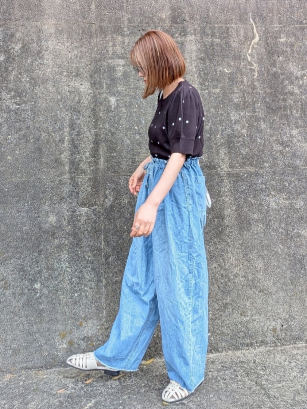 ブラック系のTシャツ/カットソー、ブルー系のデニムパンツ、ホワイト系のサンダルを着用したレディースの夏コーディネートの2枚目の写真